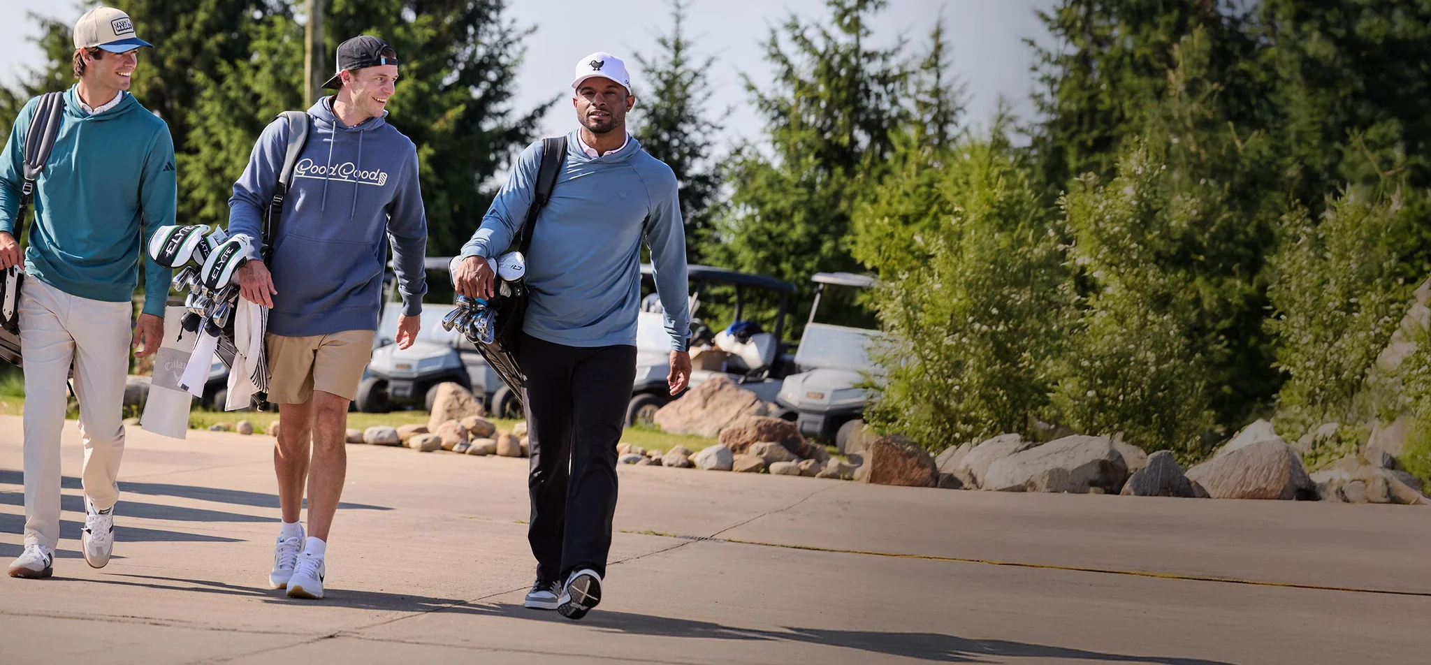 Three men walking to the range with their clubs.