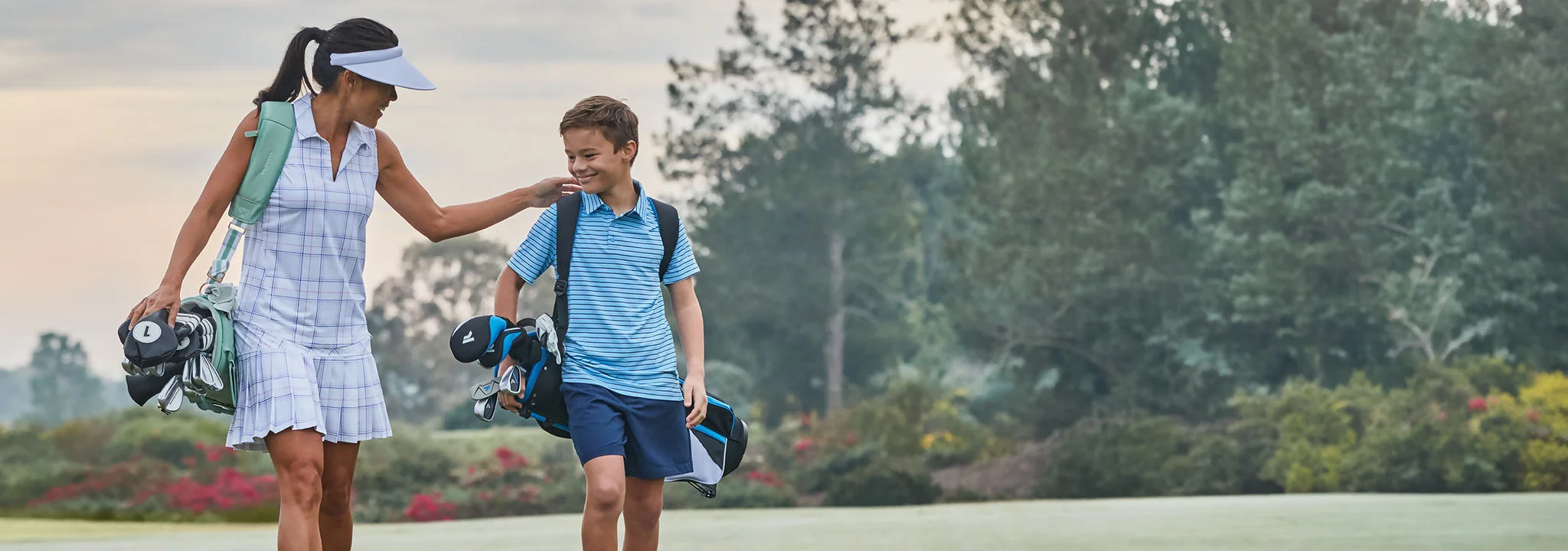 A mom and her son walking on a golf course.
