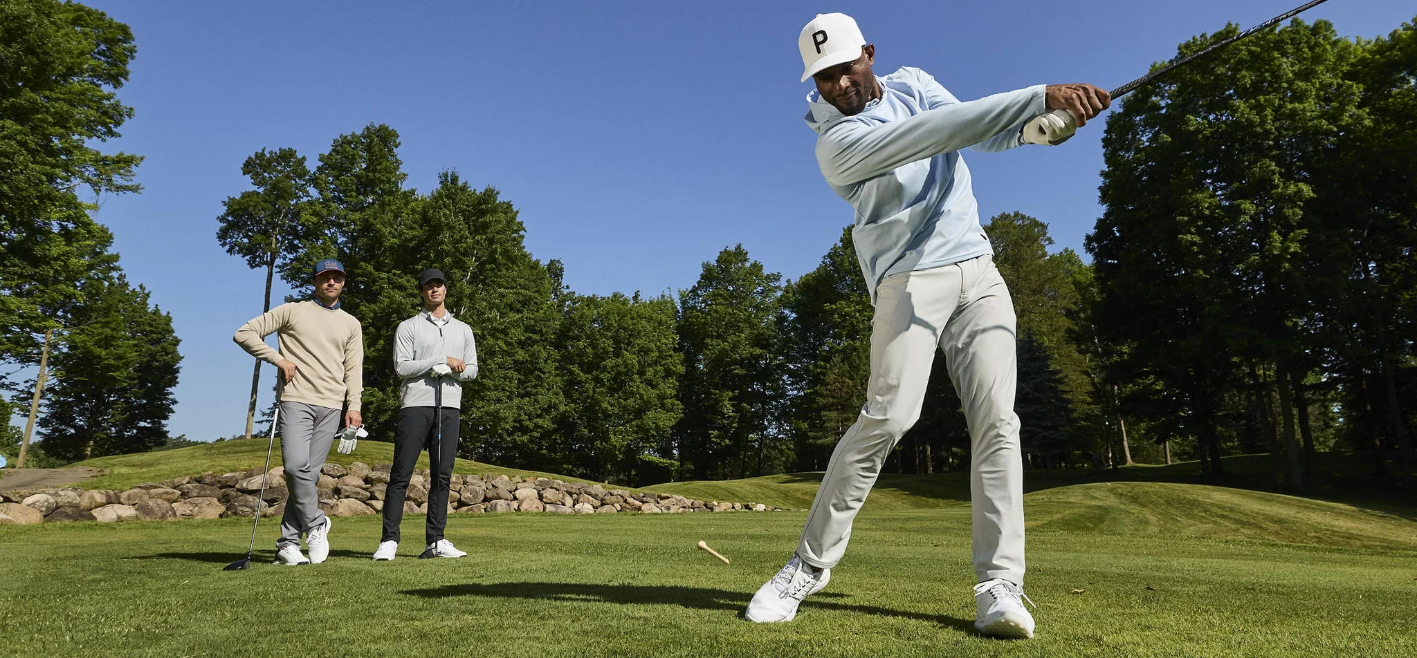 A man driving at a tee box.