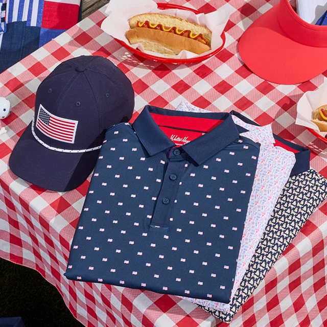 Collection of clothing and hotdog on a picnic table.