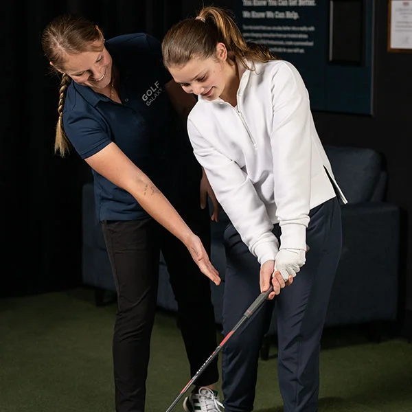 A man receiving golf lessons.
