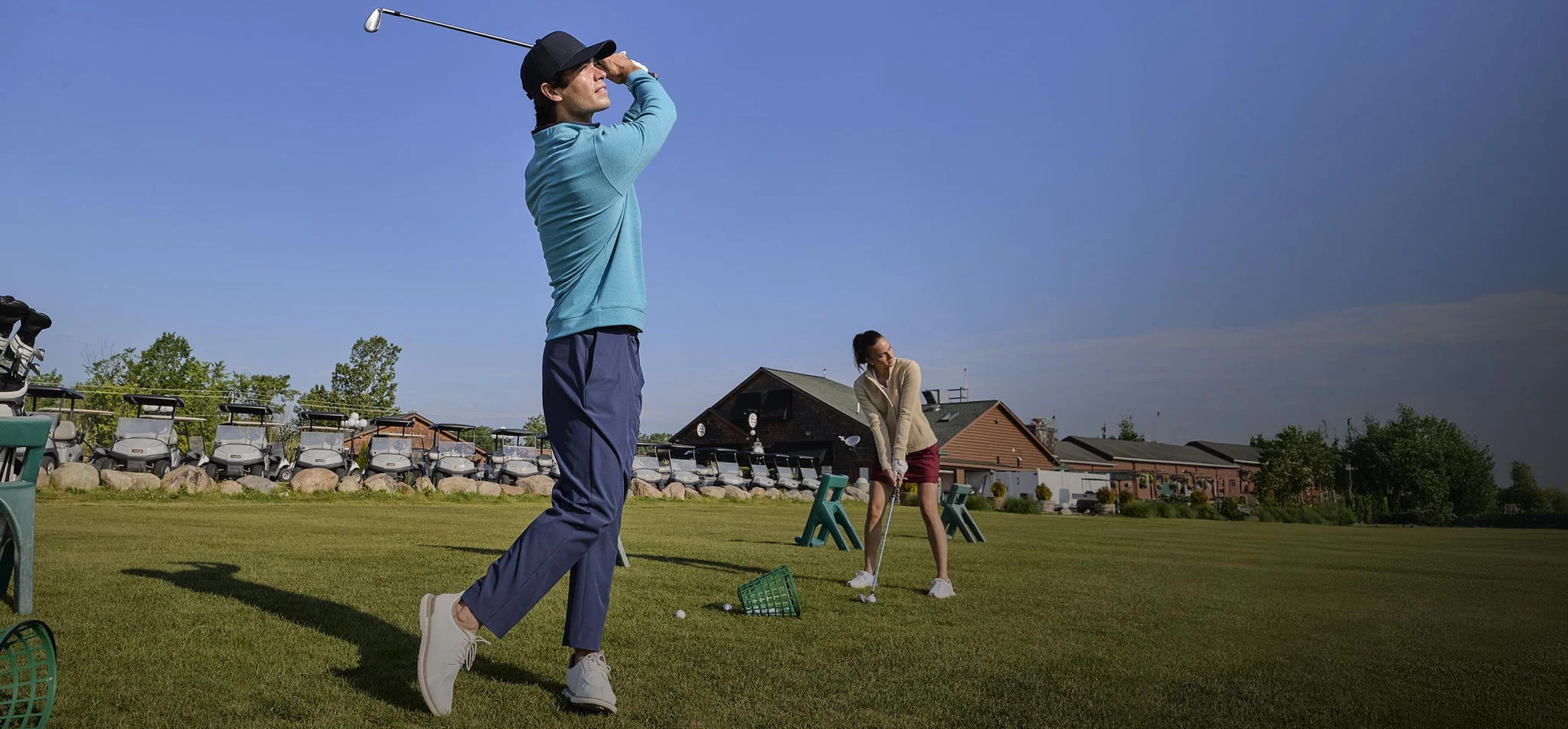 A man hitting at a driving range.