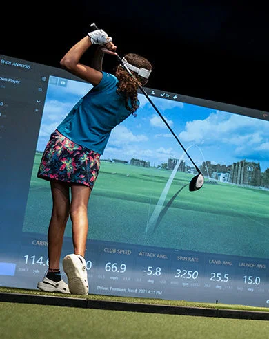 Child at a golf simulator. 