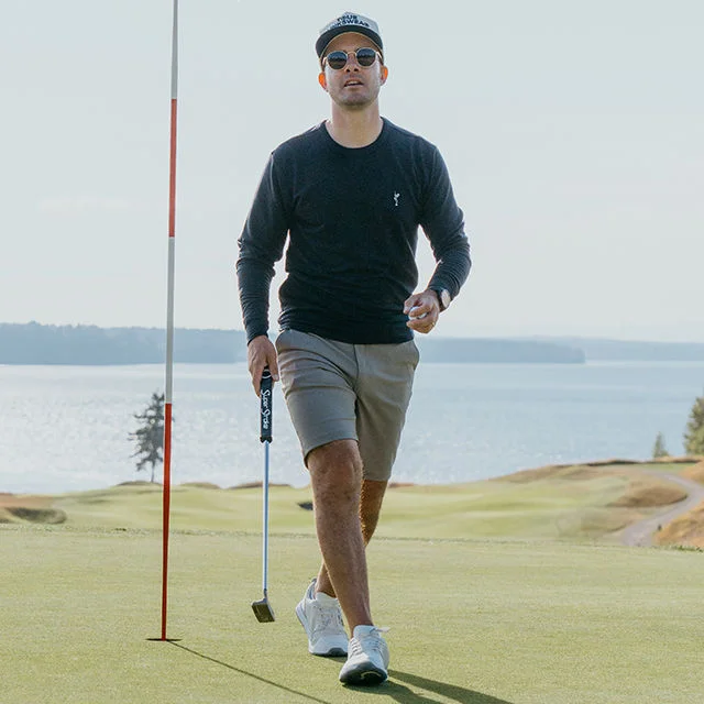 A man wearing TRUE Linkswear walking off of a green.