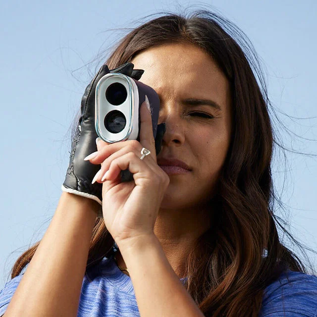 A woman using a blue tees range finder.
