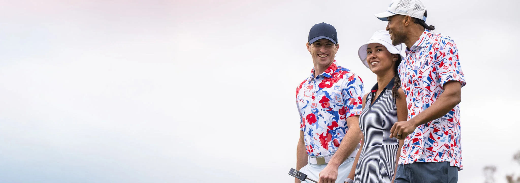 Two men and a woman walking off of a putting green wearing American themed golf apparel.