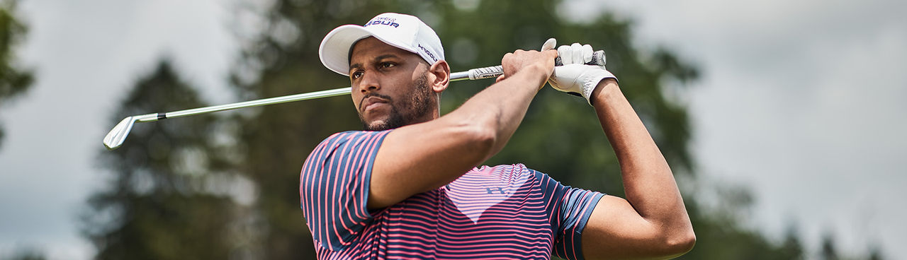 A man fallowing his ball after hitting it with an iron.