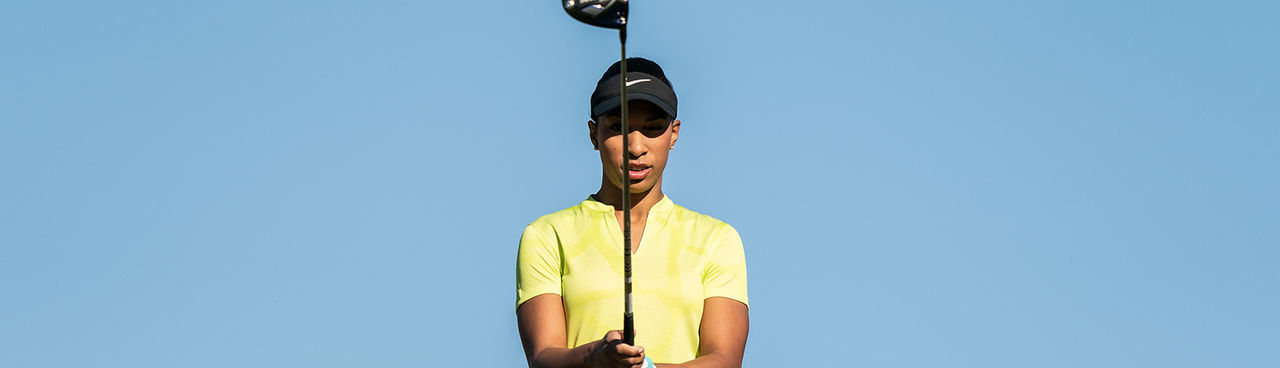 A woman holding a driver.