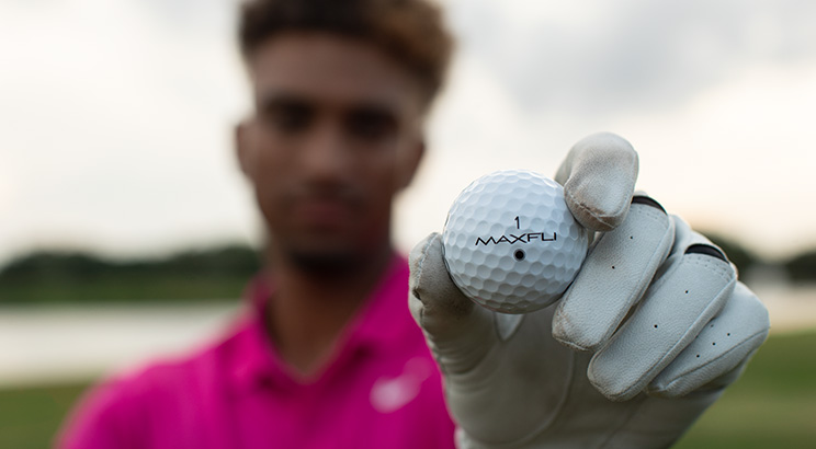 An image of a golfer holding a golf ball. 