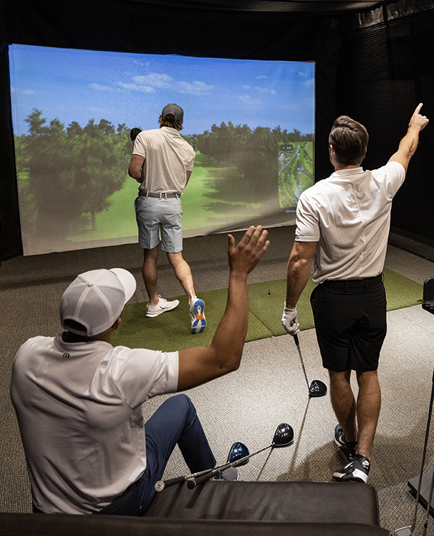 A group of golfers playing a round in the hitting bay.